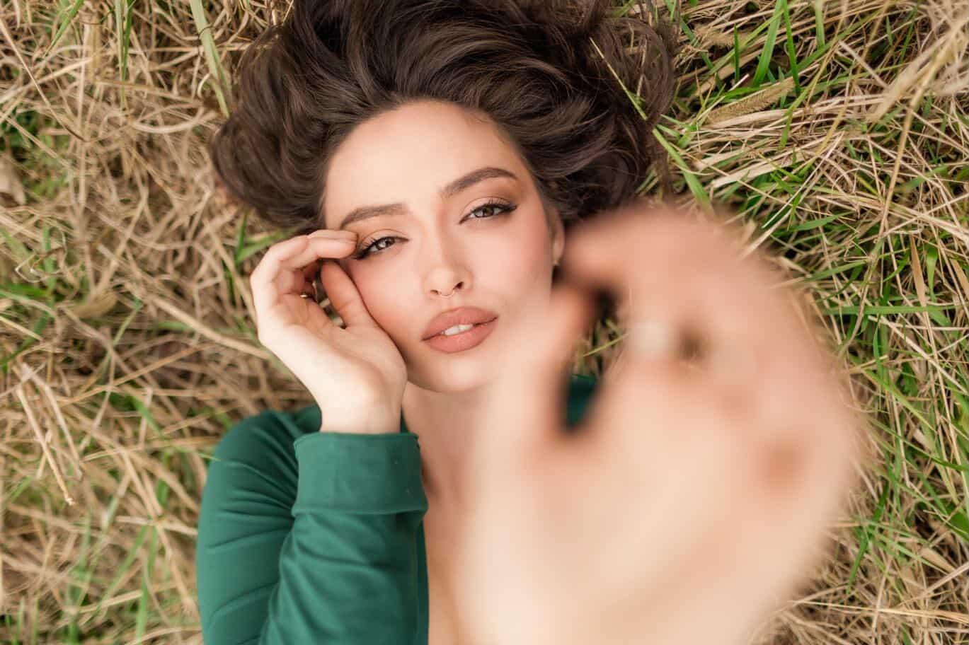 Portrait in green dress lying in the grass